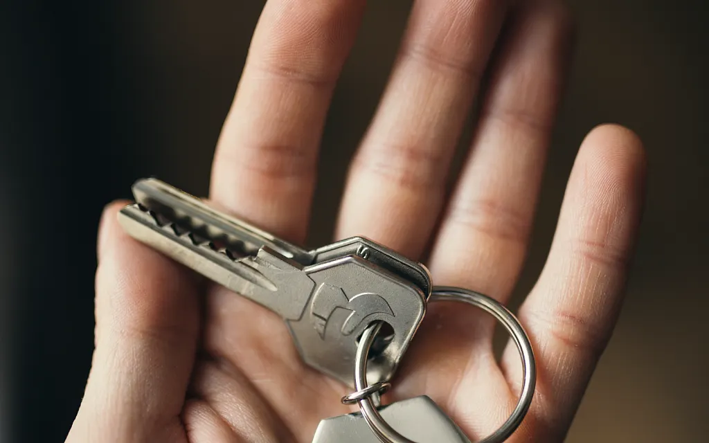 Hand hält einen Schlüsselbund mit Anhänger